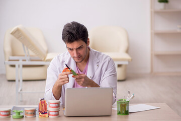 Young male dentist working in the clinic