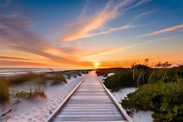 Fototapeta premium Long boardwalk leading to the white sand beach and ocean water at sunset with few shrubs on sides.