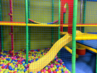 Colored ball park for children and slide with net around