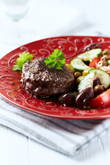 Fried hamburger steak with fresh salad. Wooden background. Close up.
