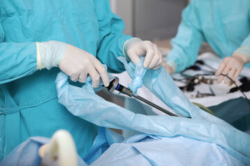 Laparoscopic instruments in the hands of a surgeon. Laparoscopic surgery. Surgery through small...