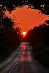 Sunset on the road. The sun sets at the end of the road