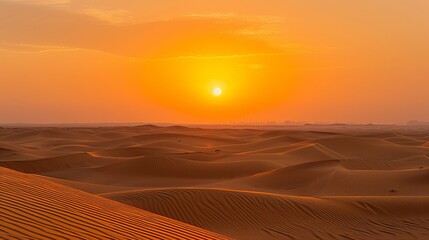 The sun sets over the vast desert sands, casting golden hues across the horizon in Dubai, United Arab Emirates.