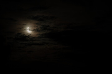 A narrow semicircle of the moon in cloudy cloudy weather. Sickle, crescent moon at dusk to overlay...