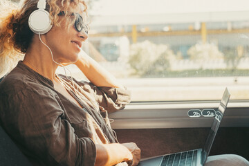 Modern travel lifestyle people with happy smiling woman listening music with headphones and laptop...