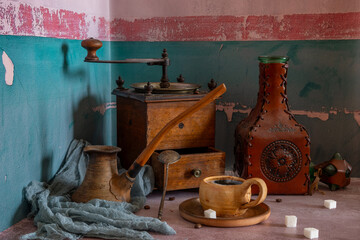 Hot, aromatic coffee in a ceramic cup and an old wooden coffee grinder. Vintage.