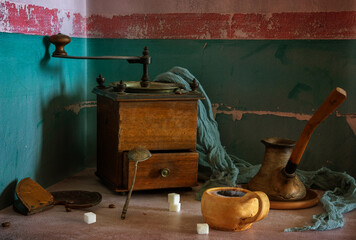 Hot, aromatic coffee in a ceramic cup and an old wooden coffee grinder. Vintage.