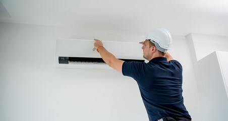 technician cleans air conditioner system in a modern apartment.