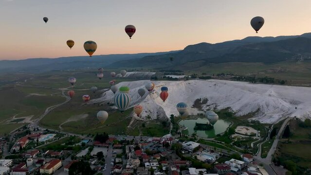 Hot air balloons and Natural travertine pools at sunrise in Pamukkale, 