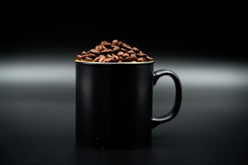 coffee beans and coffee mug filled with beans close up