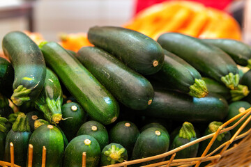zucchinis in a wooden basket at a vegetable stand