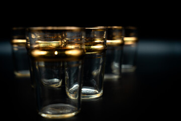 glass of water with gold rings on black 