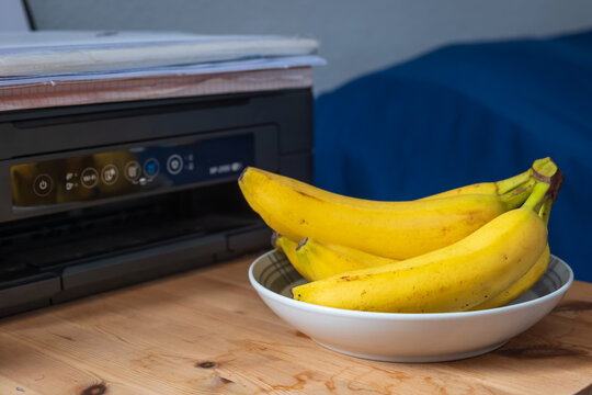 Fresh ripe banana fruit on home office table next printer