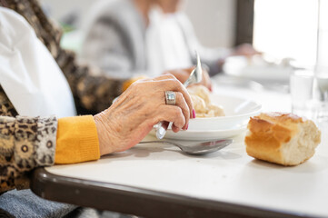 Close up of an elderly woman having lunch at retirement home. High quality photo