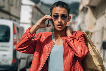 young man with shopping bags and phone on the street