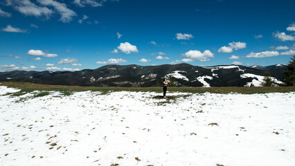 A woman does yoga and meditates high in the snowy mountains on a sunny day. The concept of yoga and...