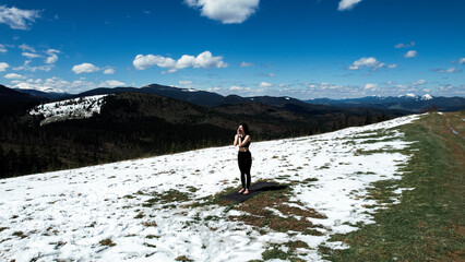 A woman does yoga and meditates high in the snowy mountains on a sunny day. The concept of yoga and meditation. Concern for mental health