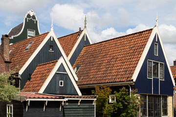 Typical wooden houses with gables along the river in the Dutch picturesque village of De Rijp in...