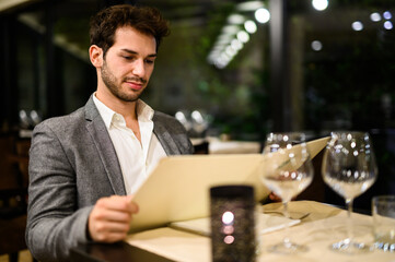 Young man browsing menu in elegant restaurant