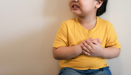 fat kid put yellow tight shirt chest pain severe heartache, heart disease or heart attack. hospital life insurance concept, World heart health day, doctor day, world hypertension day.