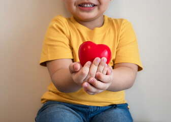 red heart in hand fat kid put yellow tight shirt, health care, organ donation, family life insurance, world heart day,brain stroke.