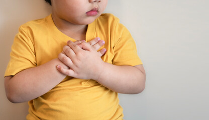 fat kid put yellow tight shirt chest pain severe heartache, heart disease or heart attack, hospital life insurance concept, World heart health day, doctor day, world hypertension day.