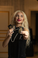 Portrait of a young beautiful blonde girl in a black dress in the studio.