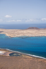 Views of the island of La Graciosa from the viewpoint of El Rio. Turquoise ocean. Blue sky with big white clouds. Caleta de Sebo. Town. volcanoes. Lanzarote, Canary Islands, Spain
