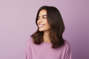 Fototapeta premium Portrait of happy smiling young woman looking up, over violet background
