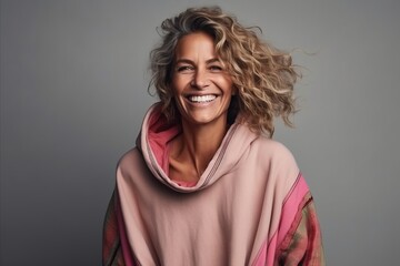 Fototapeta premium Portrait of a happy mature woman with curly hair wearing a pink hoodie
