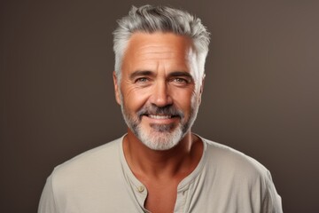 Obraz premium Portrait of a smiling mature man with grey hair and beard.
