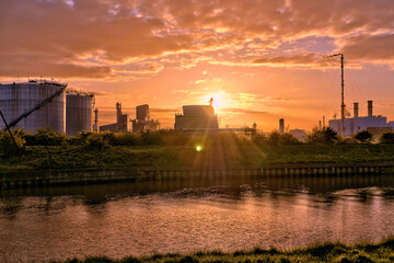 HDR Oil refinery, cooling towers, with smoke, the sun setting.
