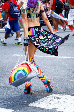 New York City, NY  USA  Pride March. Person walking across 5th avenue in rainbow platform boots. 