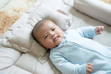 Happy adorable asian baby boy relaxing on bed,Newborn child