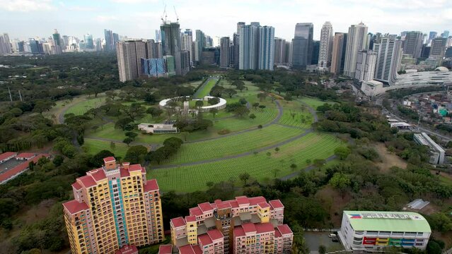 Taguig, Metro Manila, Philippines - Aerial of American Memorial Cemetery and Bonifacio Global City or BGC.