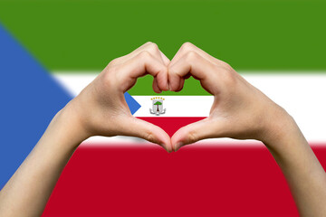 Equatorial Guinea flag with two hands heart shape, express love or affection concept, support or 