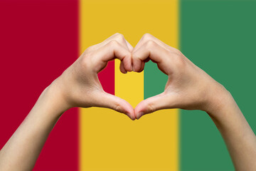 Guinea flag with two hands heart shape, express love or affection concept, patriotism and 