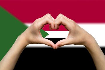 Sudan flag with two hands heart shape, patriotism and nationalism idea, express love or affection 