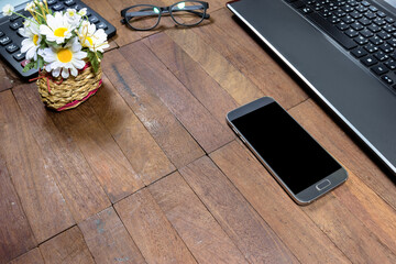 smart phone and office equipment on wooden table