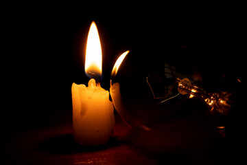Incandescent lamp and candle in the dark at home