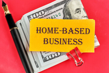 Text Home based business on a sticker lying on dollar bills on a red background, next to a fountain...
