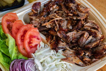 Greek gyros are a Mediterranean street food with rotisserie-cooked meat, fresh tomato, onion, and tzatziki sauce, served in a warm pita for a flavorful, savory snack.