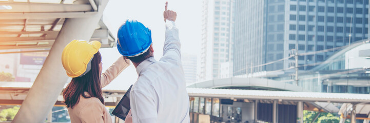Banner Two engineer women businessman look at blueprint architecture building contractor. Team Engineer holding project planing partner teamwork. Two woman man meeting teamwork with copy space