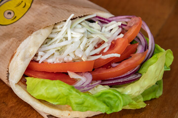 A delightful vegetarian healthy sandwich bursting with flavors. Crisp green salad leaves, juicy tomatoes, savory white cheese, and zesty onions, all nestled between slices of fresh bread