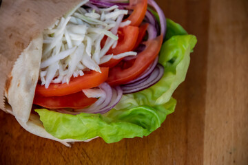 A delightful vegetarian healthy sandwich bursting with flavors. Crisp green salad leaves, juicy tomatoes, savory white cheese, and zesty onions, all nestled between slices of fresh bread