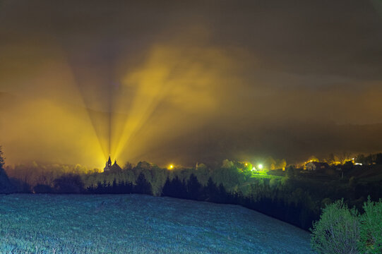 View of the church in the fog, illuminated by light in the Bieszczady mountains, Terka town.