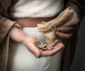 A handful of silver coins in the hands of an old man