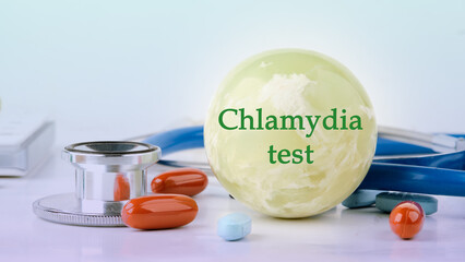 Medical concept. Chlamydia Test text on the balloon next to medical paraphernalia and pills