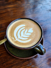 Sideway shop coffee, a cup of hot latte art coffee on wooden background.