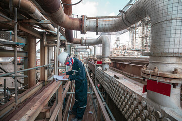 Male worker inspection at steel long pipes and pipe elbow in station oil factory fin fan during...